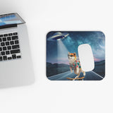 Mouse pad with UFO dog design placed next to laptop on desk