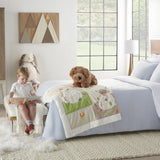 Little girl sitting with brown dog pillow on white bedspread