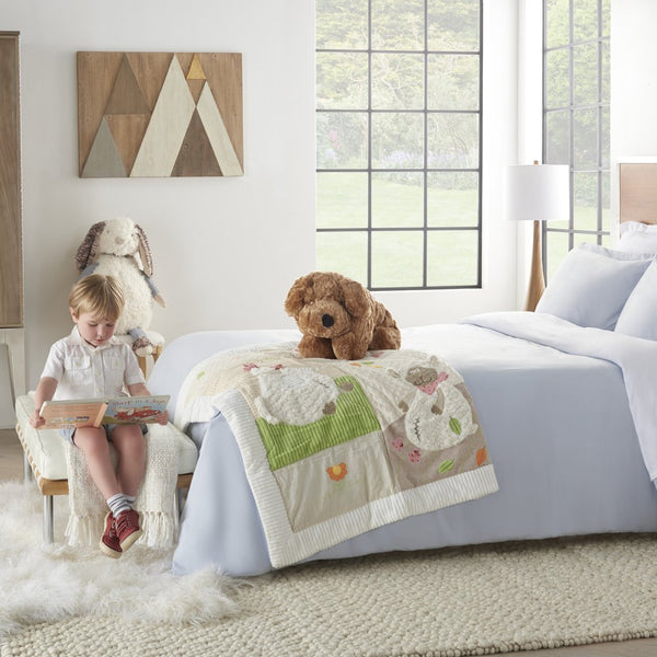 Little girl sitting with brown dog pillow on white bedspread
