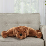 Stuffed brown dog pillow placed on light gray sofa in daylight
