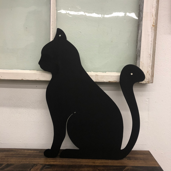 Black metal cat silhouette wall art displayed against a vintage window background on wooden surface