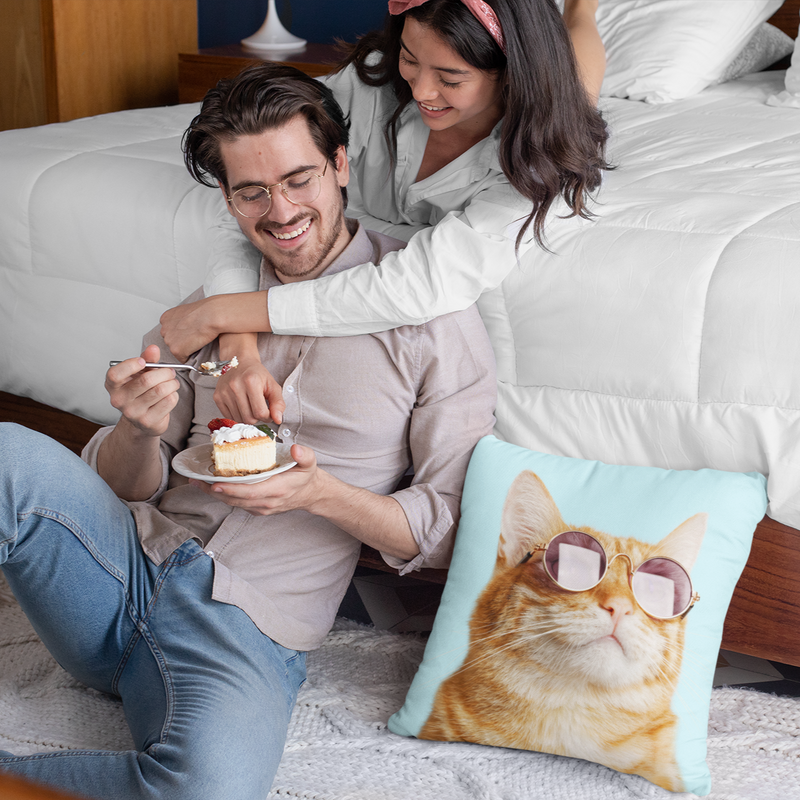 Couple relaxing on couch with funny cat-themed decorative pillow