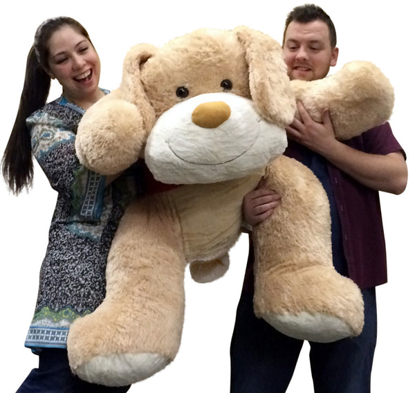 Front view of two people holding large romantic plush dog with cute expression