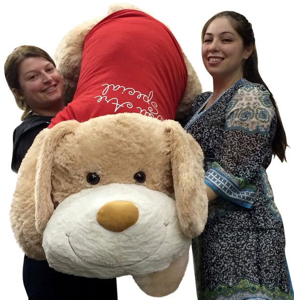 Two women holding a giant 60-inch plush Valentine’s puppy with red “You're Special” shirt