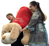 Two women lifting the giant plush dog showing back of red shirt with romantic text