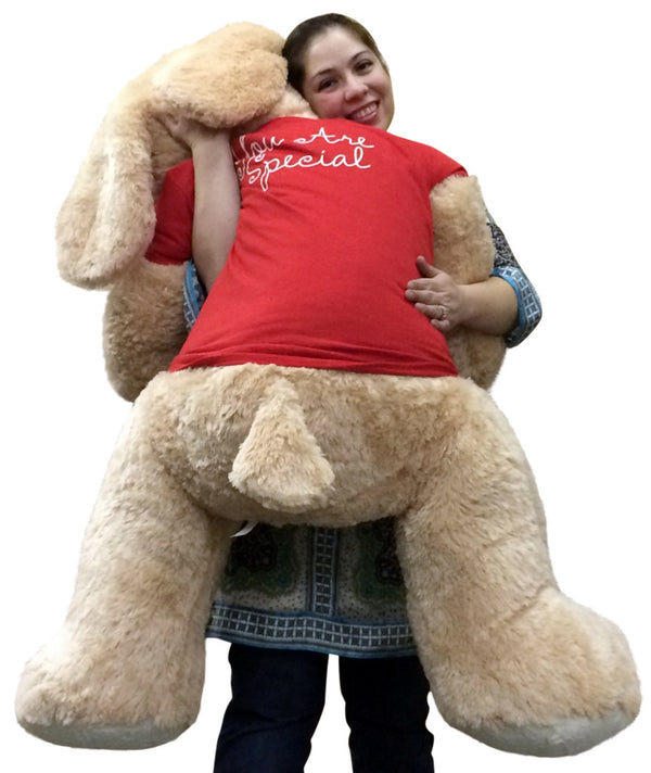 Smiling woman standing with large Valentine’s plush puppy gift